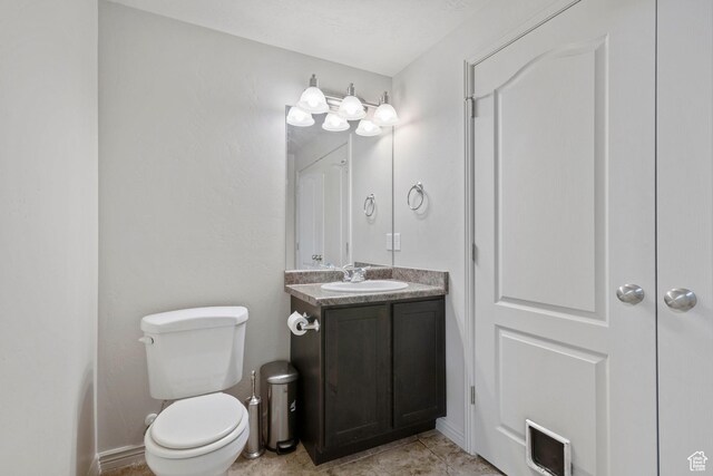 half bath featuring toilet and vanity