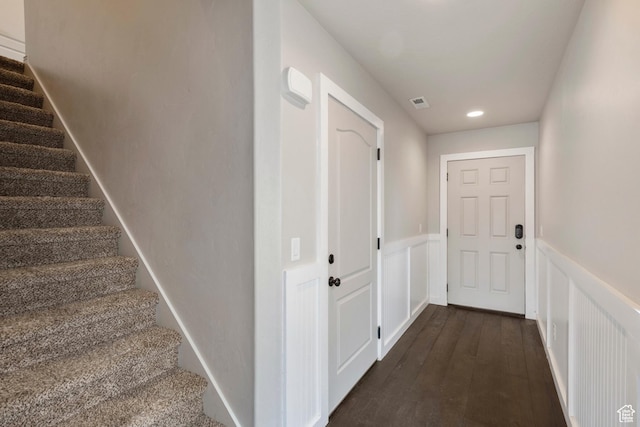 stairs with wainscoting, wood-type flooring, recessed lighting, and a decorative wall