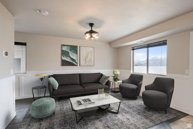living area featuring wainscoting, wood finished floors, and a decorative wall