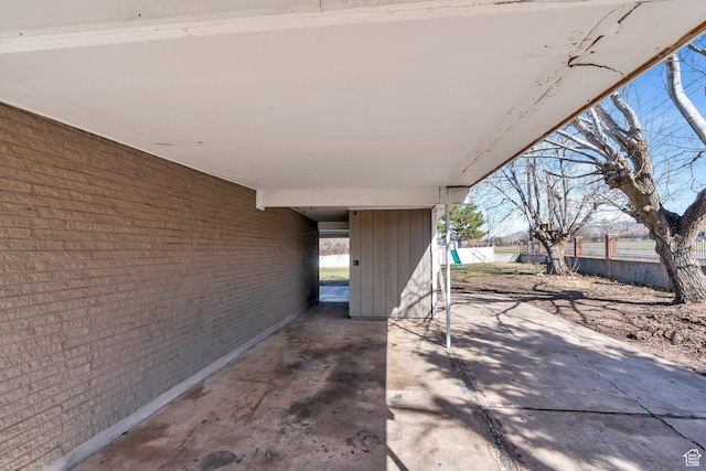 view of patio / terrace with an attached carport and fence