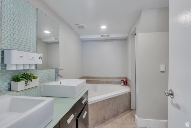bathroom featuring a sink, a bath, visible vents, decorative backsplash, and double vanity