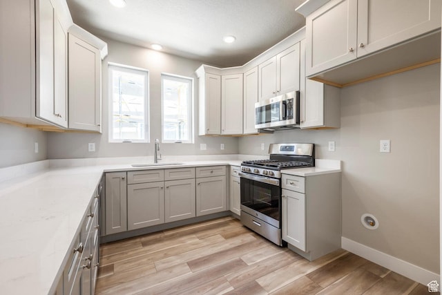2746 E 1060 S, Spanish Fork, UT 84660 - kitchen featuring baseboards, a sink, stainless steel appliances, and light wood finished floors