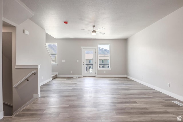 2746 E 1060 S, Spanish Fork, UT 84660 - unfurnished living room featuring baseboards, wood finished floors, and a ceiling fan