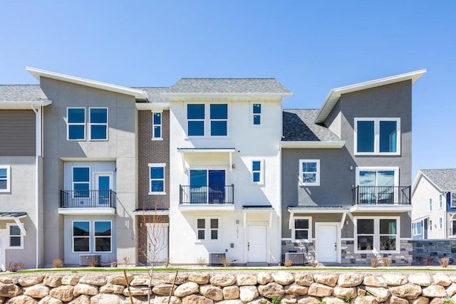 back of property featuring stucco siding and central AC