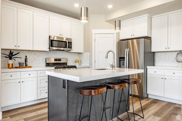 2748 E 1060 S, Spanish Fork, UT 84660 - kitchen with light wood finished floors, stainless steel appliances, a sink, pendant lighting, and a kitchen breakfast bar