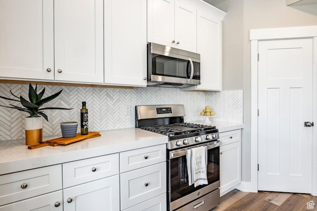 2748 E 1060 S, Spanish Fork, UT 84660 - kitchen featuring white cabinetry, light countertops, stainless steel appliances, decorative backsplash, and wood finished floors