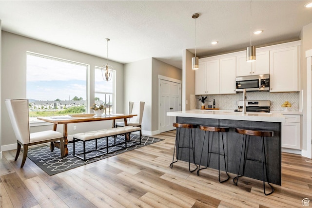 2748 E 1060 S, Spanish Fork, UT 84660 - kitchen with backsplash, light wood-style flooring, light countertops, and stainless steel appliances