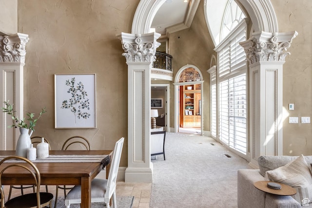 2726 E Wasatch Dr Unit 18, Salt Lake City, UT 84108 - dining room with a towering ceiling, stone tile flooring, decorative columns, and light colored carpet