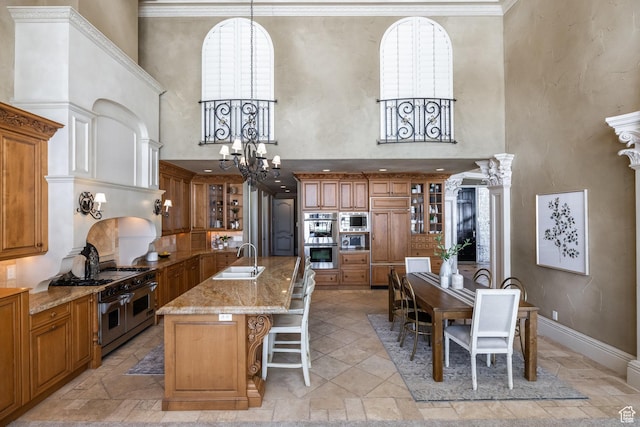 2726 E Wasatch Dr Unit 18, Salt Lake City, UT 84108 - kitchen with a kitchen breakfast bar, a chandelier, a sink, built in appliances, and brown cabinets