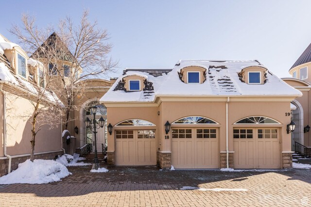 2726 E Wasatch Dr Unit 18, Salt Lake City, UT 84108 - view of front of house with driveway, stone siding, a garage, and stucco siding