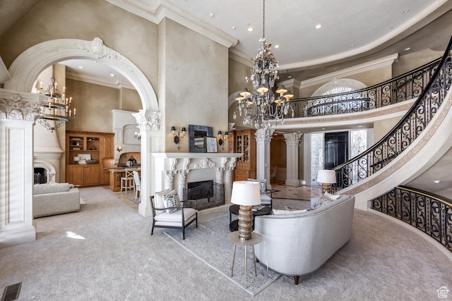 2726 E Wasatch Dr Unit 18, Salt Lake City, UT 84108 - living area featuring a fireplace, crown molding, a towering ceiling, and a chandelier