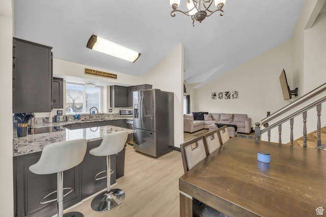 4933 S 3900 W, Roy, UT 84067 - kitchen with vaulted ceiling, light stone countertops, a chandelier, a peninsula, and appliances with stainless steel finishes