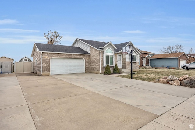4933 S 3900 W, Roy, UT 84067 - view of front of house featuring concrete driveway, roof with shingles, a gate, brick siding, and a garage