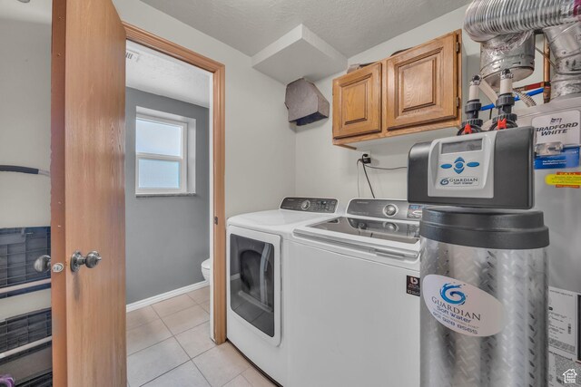 4933 S 3900 W, Roy, UT 84067 - laundry room featuring baseboards, a textured ceiling, light tile patterned flooring, cabinet space, and washer and dryer