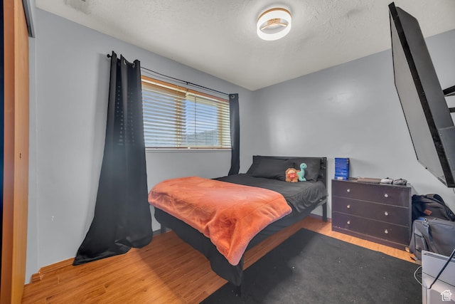4933 S 3900 W, Roy, UT 84067 - bedroom featuring visible vents, a textured ceiling, and wood finished floors