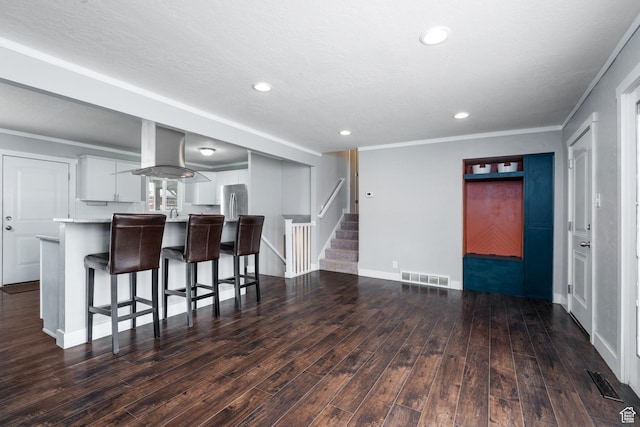 1305 N Valentine St, Salt Lake City, UT 84116 - kitchen featuring light countertops, visible vents, a kitchen breakfast bar, and wood finished floors
