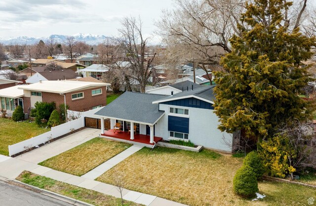 1305 N Valentine St, Salt Lake City, UT 84116 - view of front of house with concrete driveway, brick siding, a front lawn, a residential view, and a mountain view