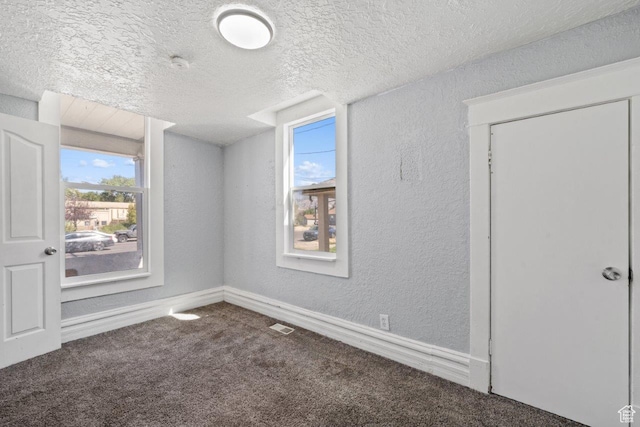 169 E 30th St S, Ogden, UT 84401 - carpeted empty room featuring baseboards, visible vents, a textured ceiling, and a textured wall