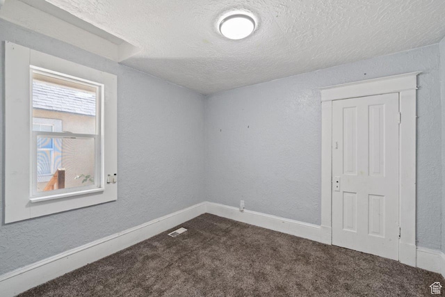 169 E 30th St S, Ogden, UT 84401 - spare room featuring visible vents, dark carpet, a textured wall, and a textured ceiling