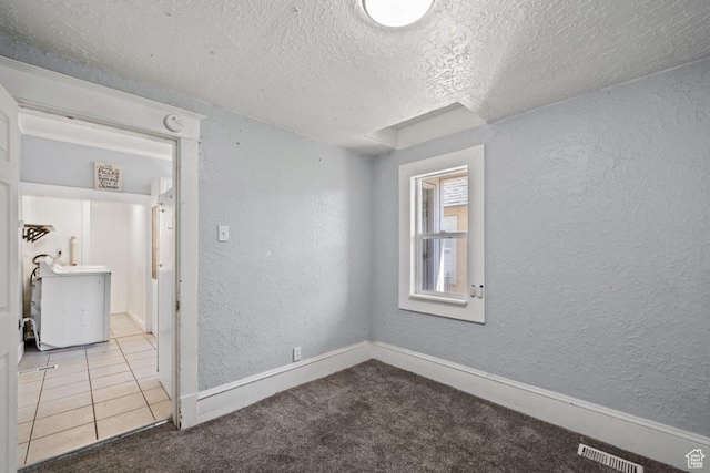 169 E 30th St S, Ogden, UT 84401 - tiled empty room featuring visible vents, carpet, a textured wall, and a textured ceiling