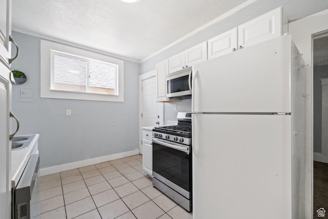 169 E 30th St S, Ogden, UT 84401 - kitchen featuring white cabinetry, light tile patterned floors, stainless steel appliances, baseboards, and a textured ceiling