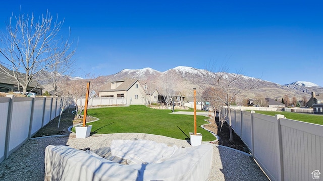 view of yard with a mountain view, a fenced backyard, and a residential view