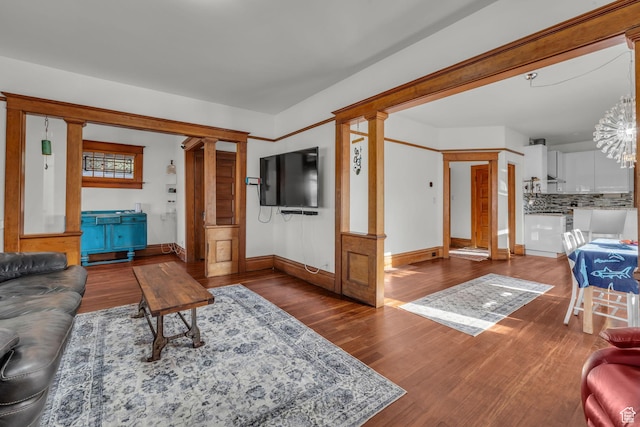 736 E 800 S, Salt Lake City, UT 84102 - living room featuring baseboards, decorative columns, wood finished floors, and an inviting chandelier