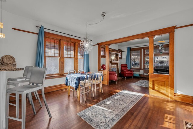 736 E 800 S, Salt Lake City, UT 84102 - dining space with dark wood-style flooring, visible vents, baseboards, ornate columns, and an inviting chandelier
