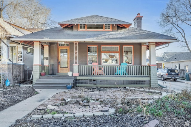 bungalow-style home featuring a chimney and a porch