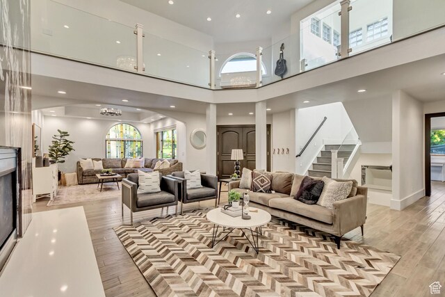 1448 E 155 S, Lindon, UT 84042 - living room with light wood-style flooring, stairs, a towering ceiling, recessed lighting, and arched walkways