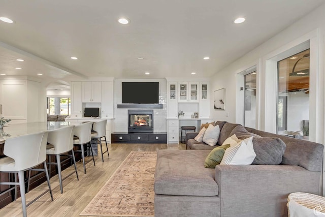 1448 E 155 S, Lindon, UT 84042 - living room featuring arched walkways, light wood-style flooring, recessed lighting, and a tile fireplace