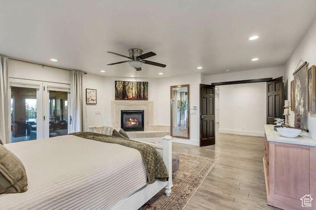 1448 E 155 S, Lindon, UT 84042 - bedroom featuring recessed lighting, french doors, light wood-type flooring, access to exterior, and a glass covered fireplace
