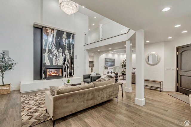 1448 E 155 S, Lindon, UT 84042 - living room with arched walkways, a multi sided fireplace, light wood-style flooring, and recessed lighting