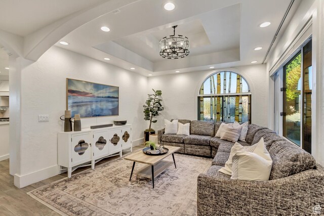 1448 E 155 S, Lindon, UT 84042 - living room with baseboards, a raised ceiling, arched walkways, light wood-style flooring, and a notable chandelier