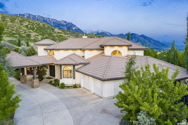 1448 E 155 S, Lindon, UT 84042 - mediterranean / spanish-style house featuring an attached garage, concrete driveway, a tile roof, stucco siding, and a mountain view