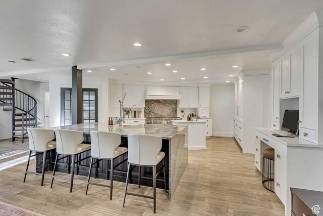 1448 E 155 S, Lindon, UT 84042 - kitchen with a kitchen breakfast bar, white cabinetry, light wood-type flooring, a spacious island, and backsplash