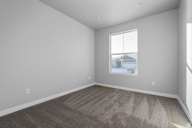 spare room featuring baseboards, dark carpet, and recessed lighting