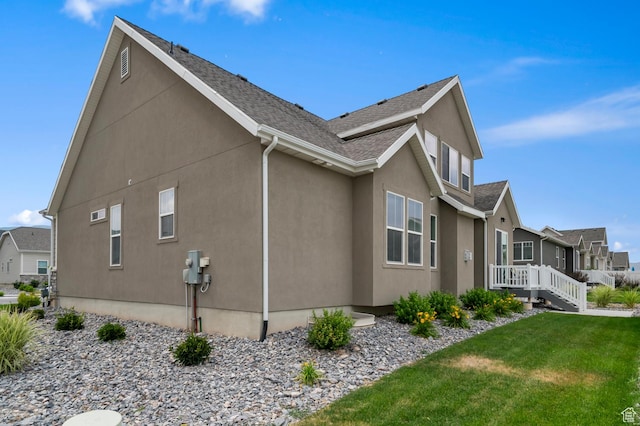 6606 N Furner Rdg, Eagle Mountain, UT 84005 - view of side of home featuring stucco siding, a lawn, a residential view, roof with shingles, and a wooden deck