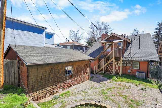 427 E 1st Ave, Salt Lake City, UT 84103 - back of property featuring central air condition unit, a shingled roof, fence, and stairs
