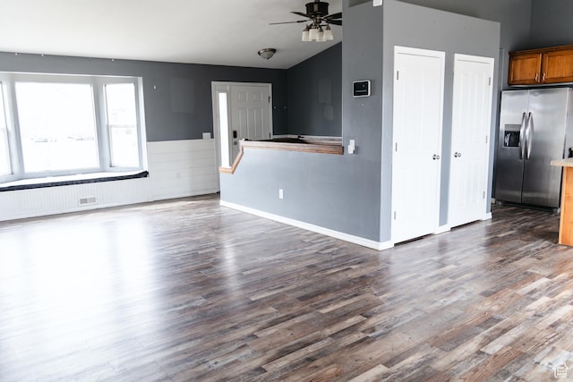 unfurnished living room featuring baseboards, lofted ceiling, dark wood-type flooring, and a ceiling fan
