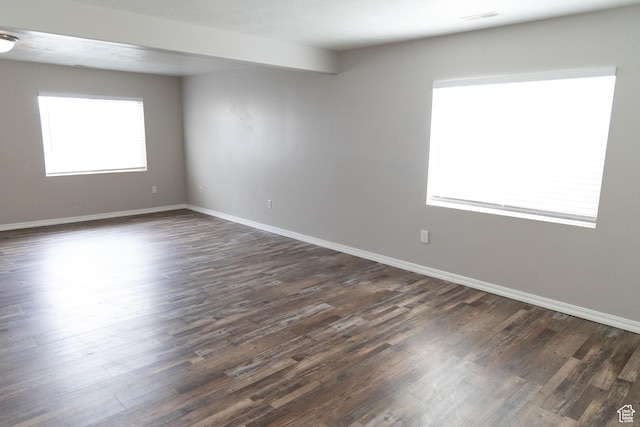 spare room featuring dark wood finished floors, baseboards, and visible vents