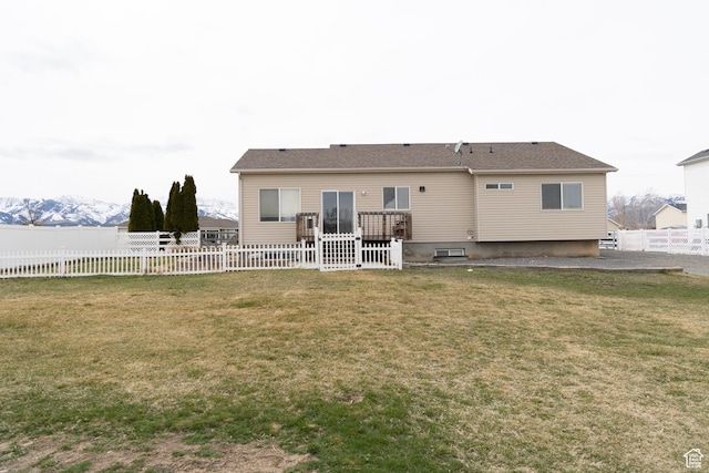 rear view of property featuring fence and a yard