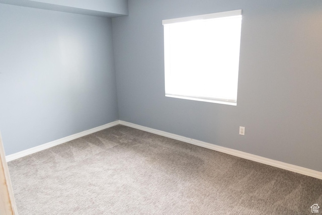 carpeted empty room with baseboards