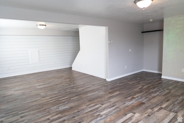spare room featuring dark wood-style floors and baseboards