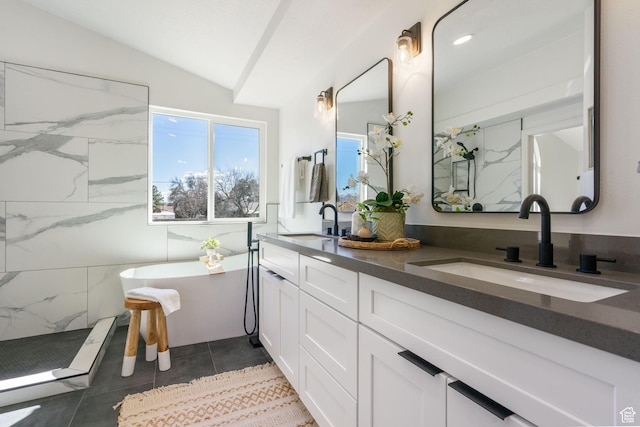full bath with a marble finish shower, lofted ceiling, and a sink