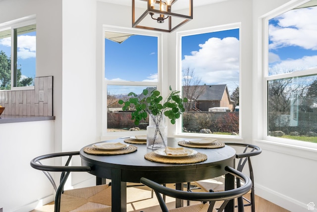 dining room featuring baseboards, wood finished floors, and a chandelier
