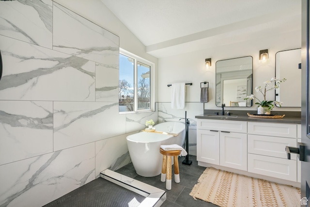 full bathroom featuring a soaking tub, vanity, tile walls, and vaulted ceiling