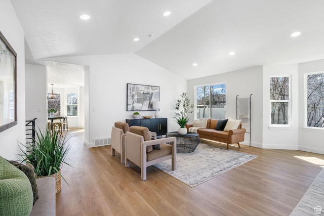 living area with a chandelier, recessed lighting, vaulted ceiling, and light wood-type flooring