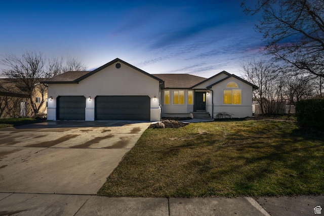 view of front of home with stucco siding, an attached garage, a front lawn, and concrete driveway