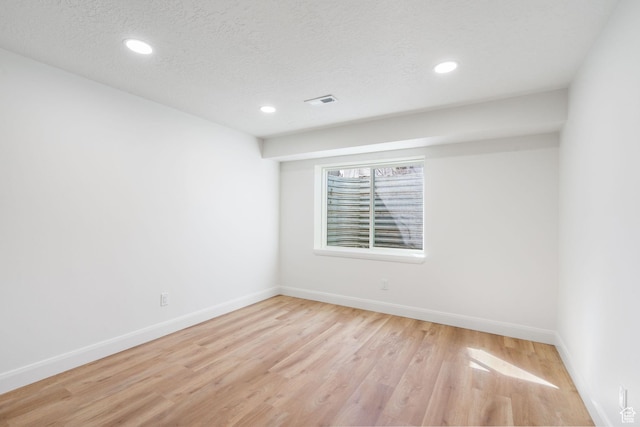 unfurnished room with recessed lighting, a textured ceiling, baseboards, and light wood-type flooring
